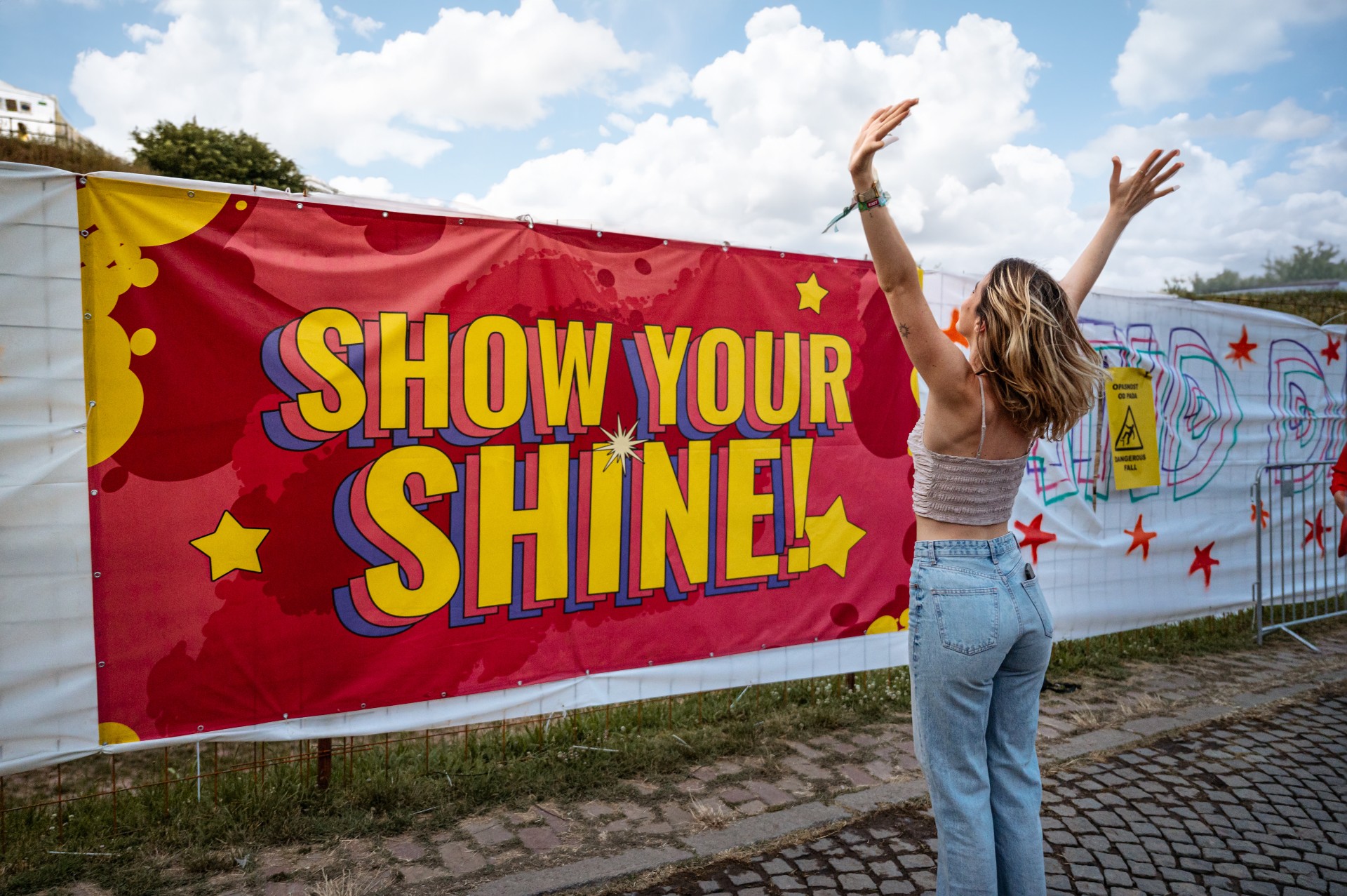 A woman standing in front of Show Your Shine sign at EXIT Festival 2023